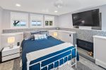 Primary bedroom on lower level boasts a mounted television & gas fireplace